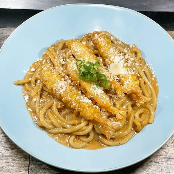 Udon noodles with creamy sauce, topped with three tempura shrimp, parmesan, and green onions.