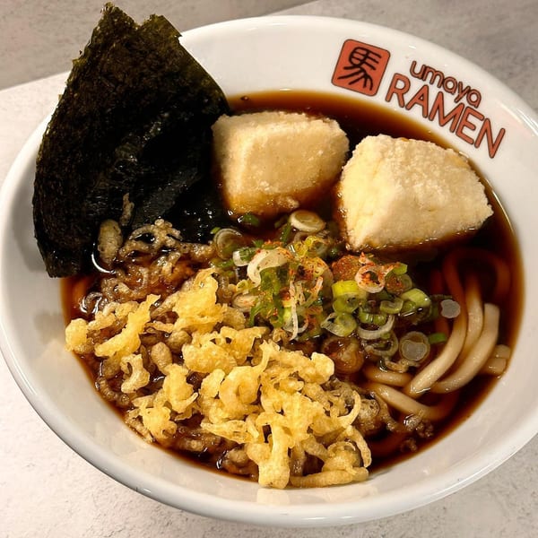 Umaya Ramen bowl with dark broth, noodles, fried tofu, seaweed, green onions, and tempura flakes.